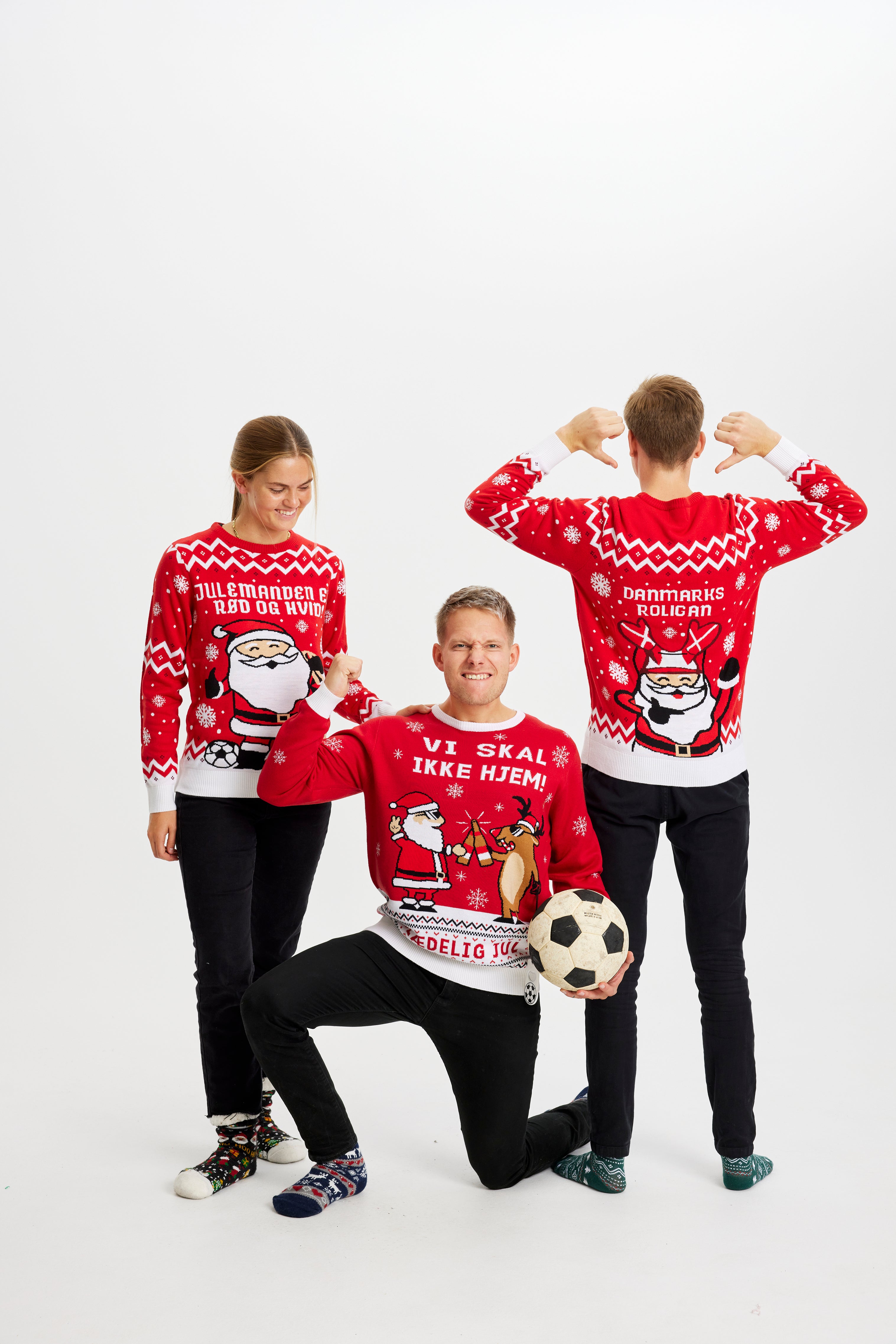 Tre person poserer sammen i røde julesweatre.